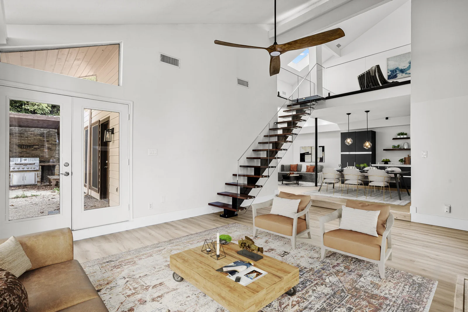 Bright Crossing Lane living room with wood floors and a sculptural staircase