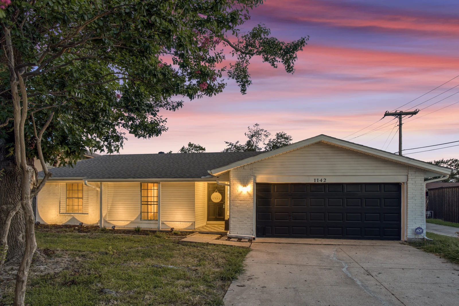 Front exterior of 1142 Via Del Rey with the porch lights on