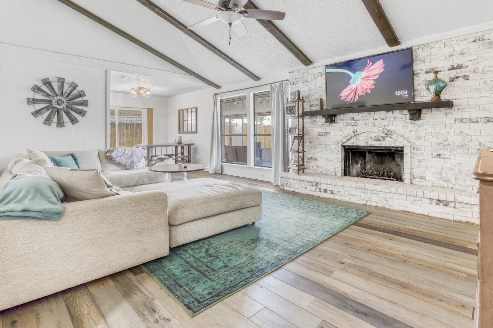 Living-room view at 1142 Via Del Rey with ceiling beams and a brick fireplace