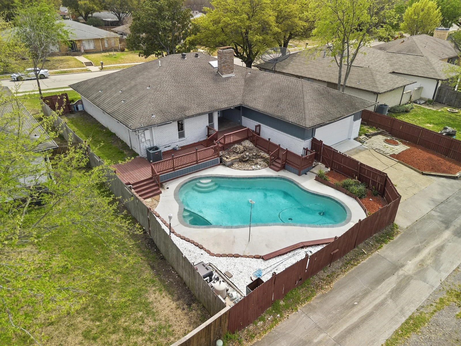 Rear aerial view of 1217 Pecan Valley Drive showing the deck and pool