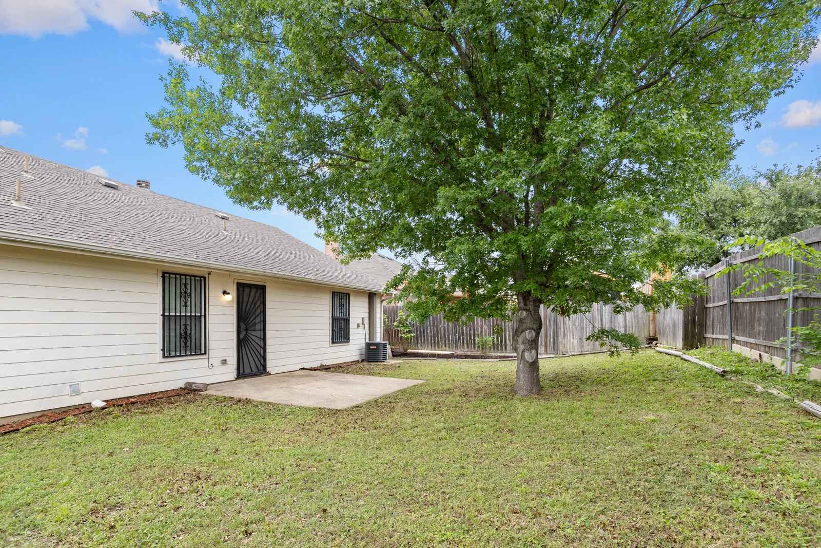 Backyard view of 1256 Cleardale Drive with a large tree, patio and rear exterior