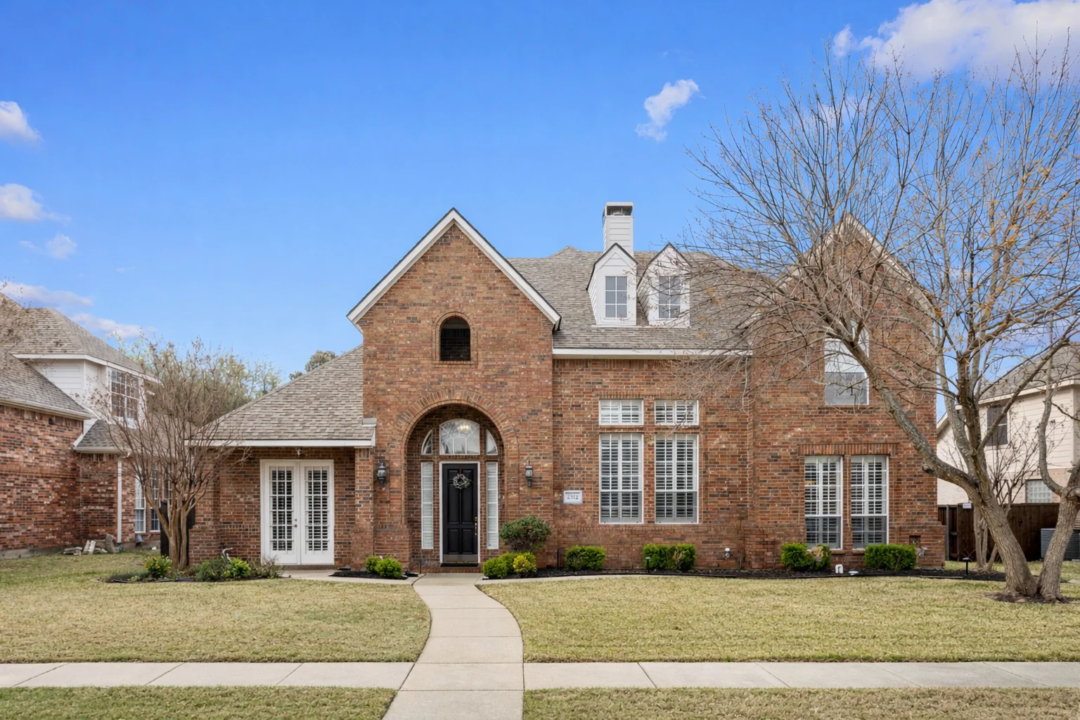 Front exterior of 2312 Scenic Drive with its arched entry and curved walkway