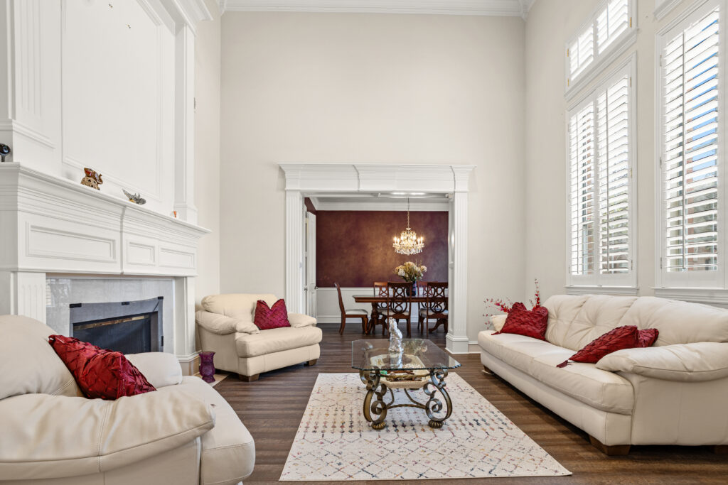 Living room at 2312 Scenic Drive, with a fireplace, tall windows and an adjoining dining room