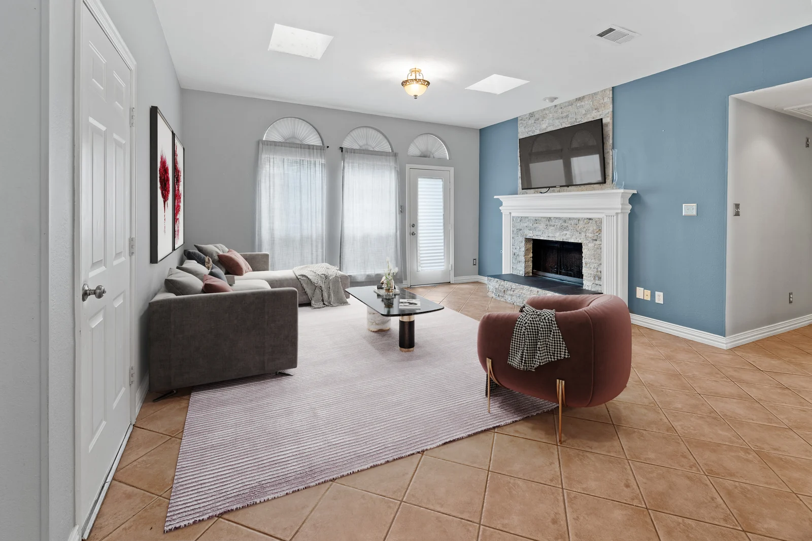 Living-room view at 4100 Crest Ridge Drive with a fireplace, arched windows and skylights