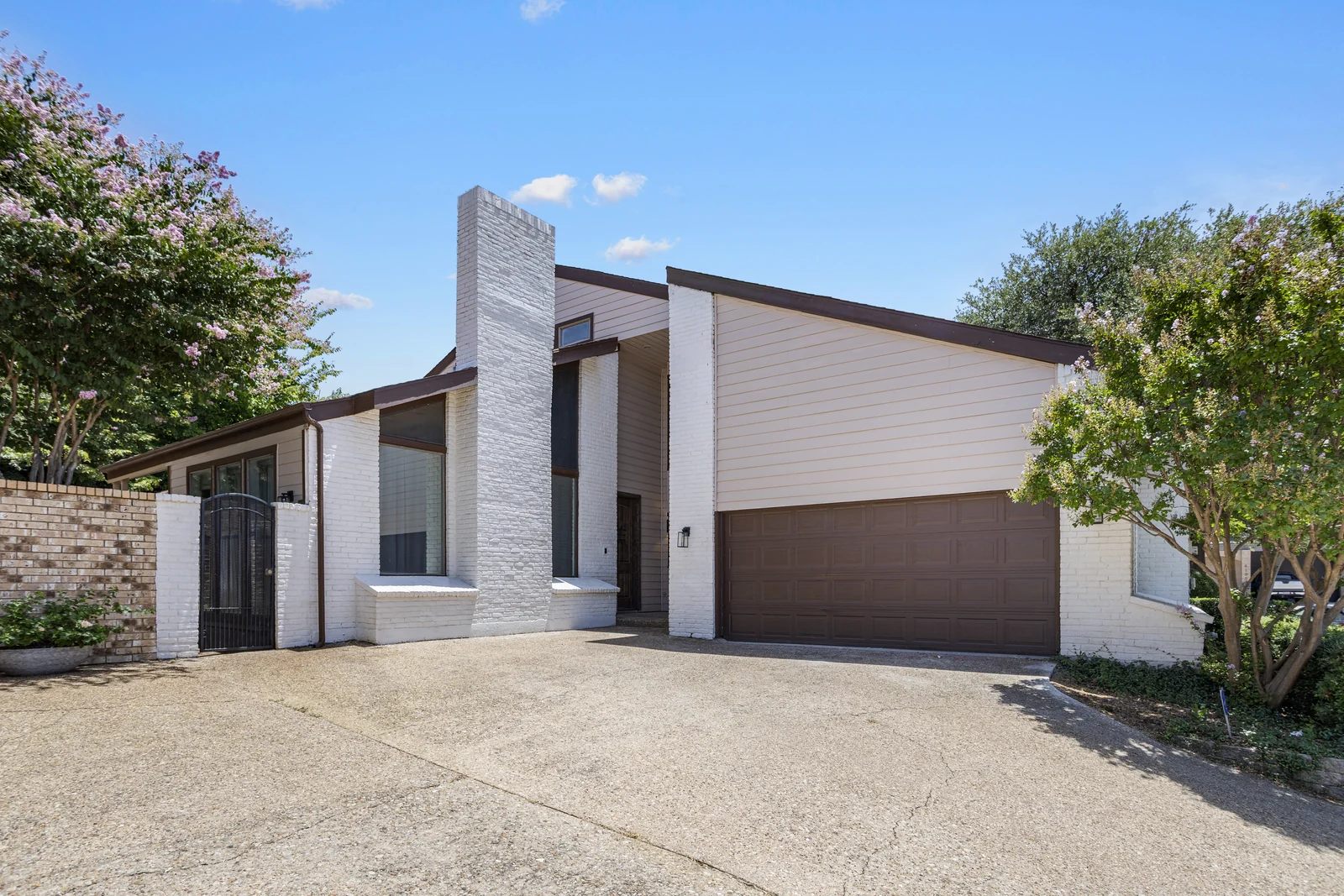 Front exterior of 4118 Crossing Lane with an angled roofline, chimney and garage