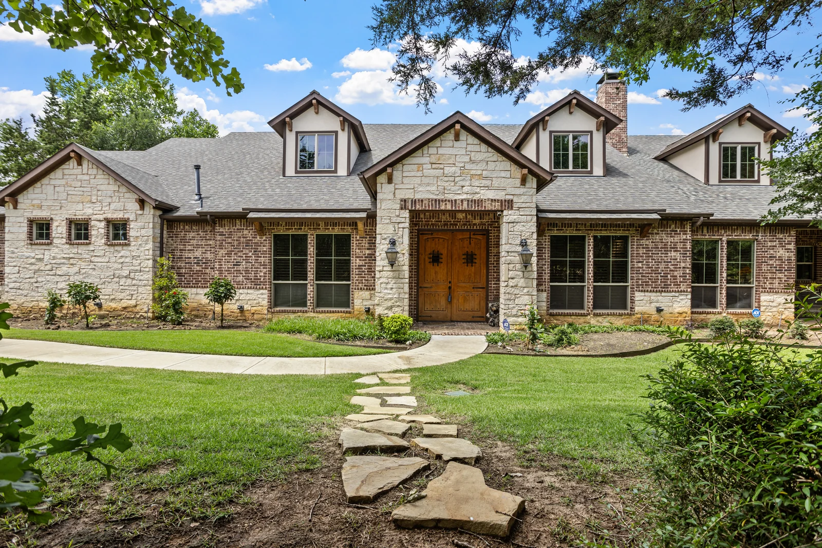 Front exterior of 5100 Swisher Road framed by tree branches