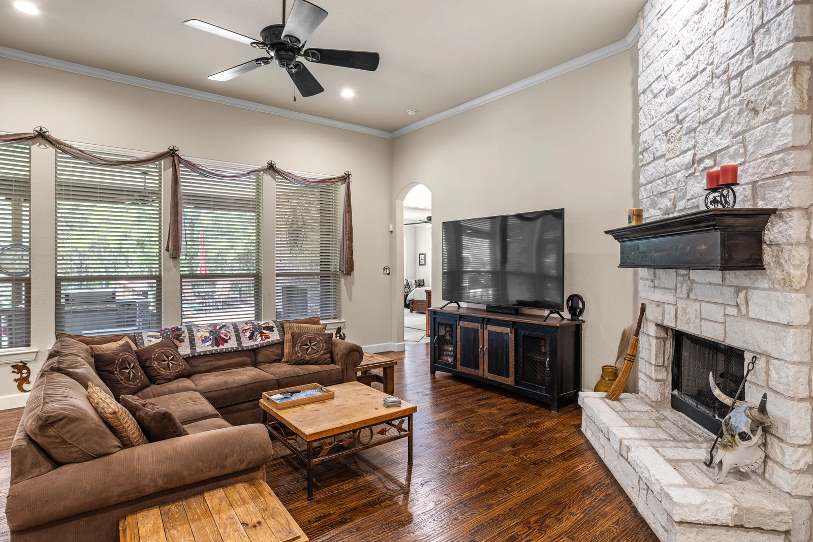 Living-room view at 5100 Swisher Road with a stone fireplace and windows