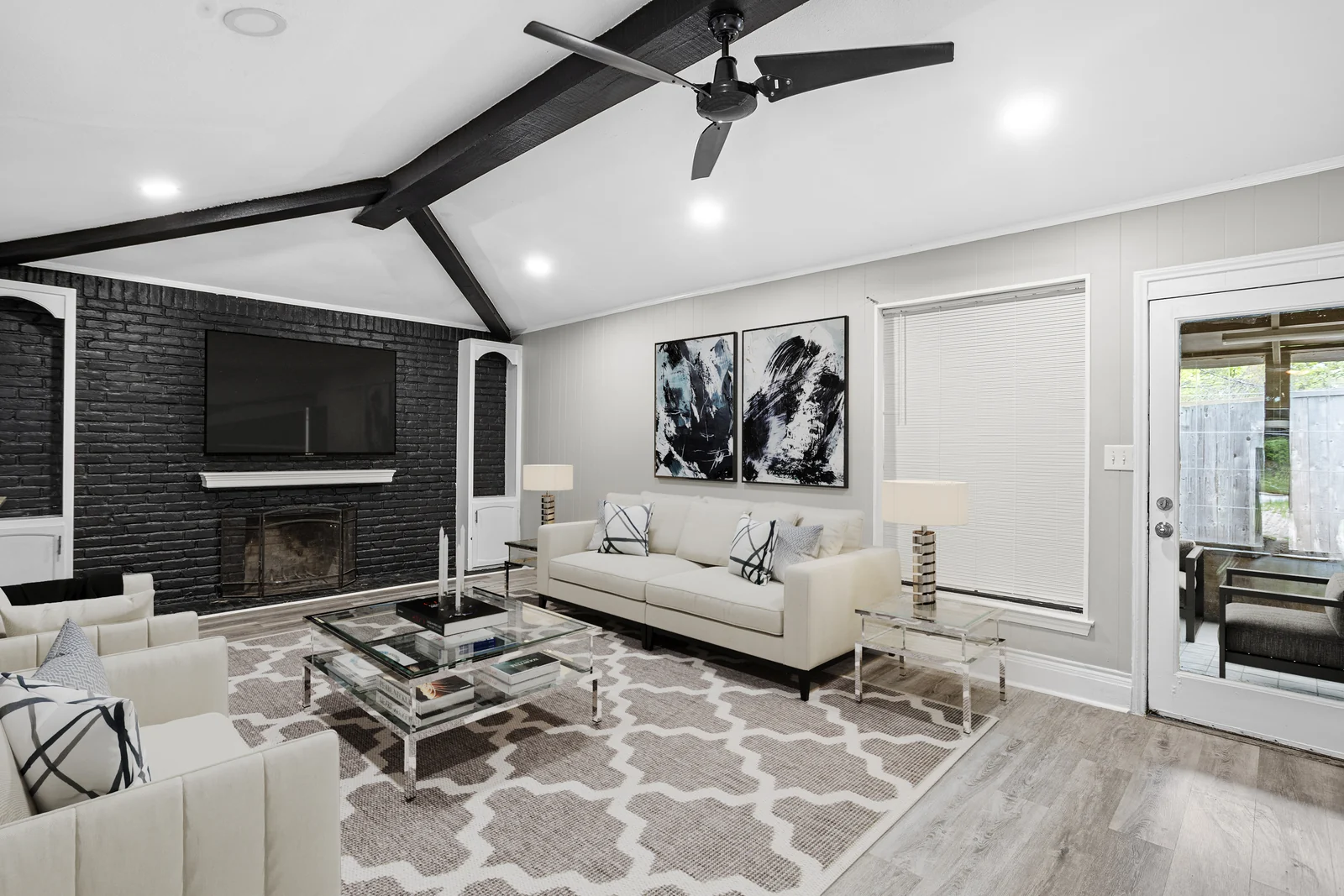 Living-room view at 5714 Tumbleweed Court with dark ceiling beams and a brick fireplace wall